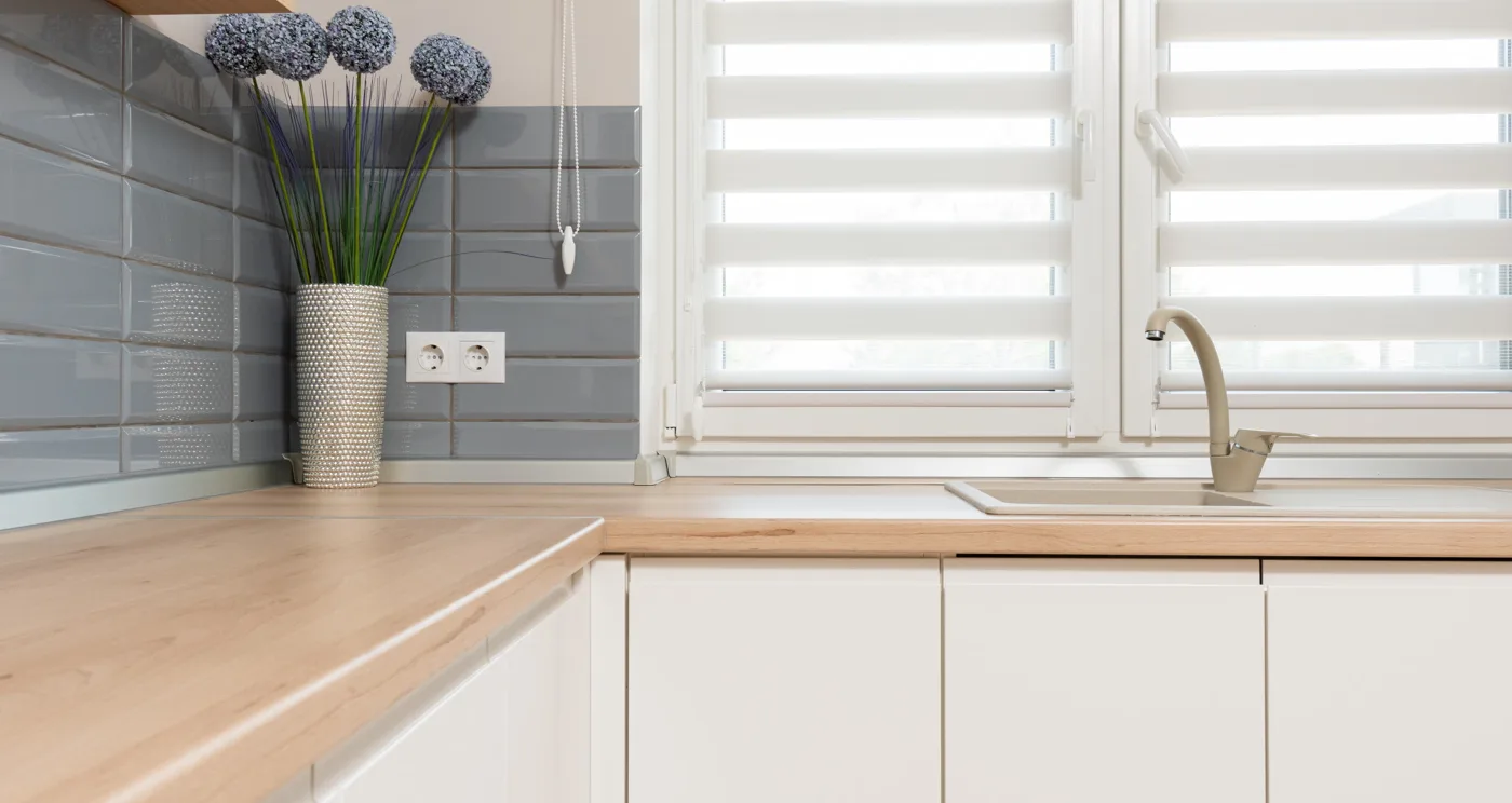Warm white cabinetry beside pale stone and light oak showing subtle undertone differences